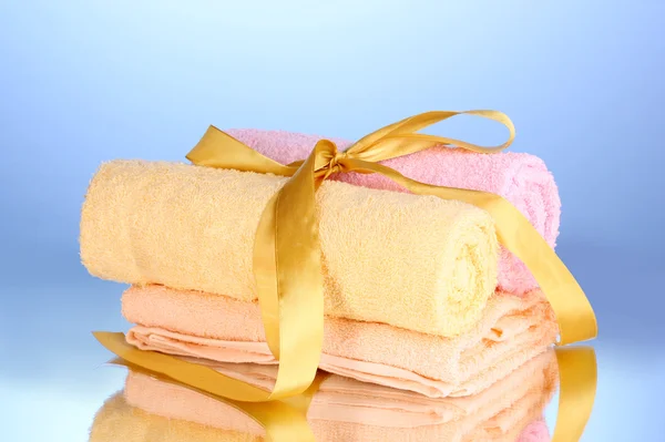 Barevné ručníky s mašlí na modrém pozadí — Stock fotografie