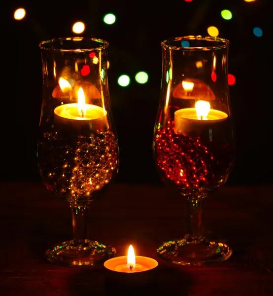 Amazing composition of candles and glasses on wooden table on bright background — Stock Photo, Image
