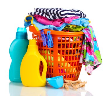 Clothes with detergent and washing powder in orange plastic basket isolated on white clipart