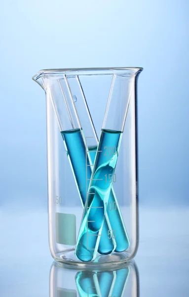 青色の背景に反射とビーカーを測定で青い液体研究所管 — ストック写真
