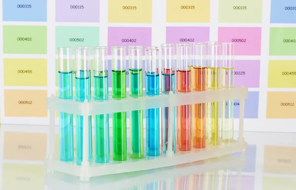Tubos de ensayo con líquido de color sobre fondo de muestras de color —  Fotos de Stock