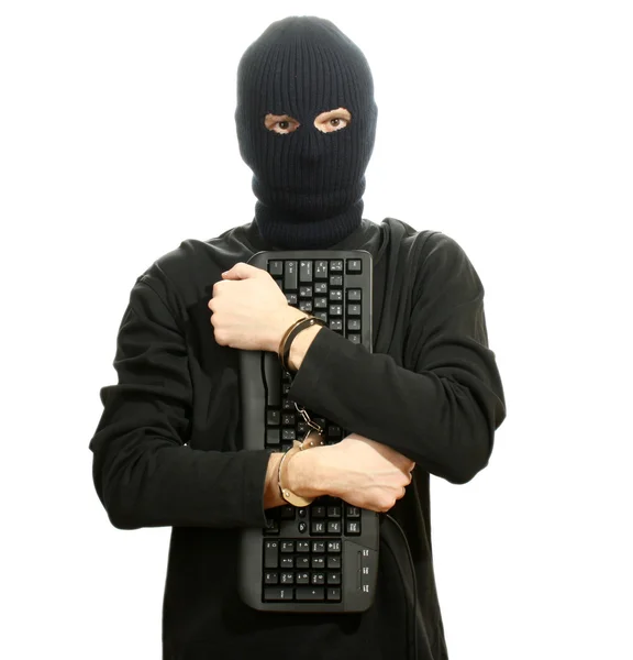 Haker w czarnej masce w kajdankach z klawiatury na białym tle — Zdjęcie stockowe