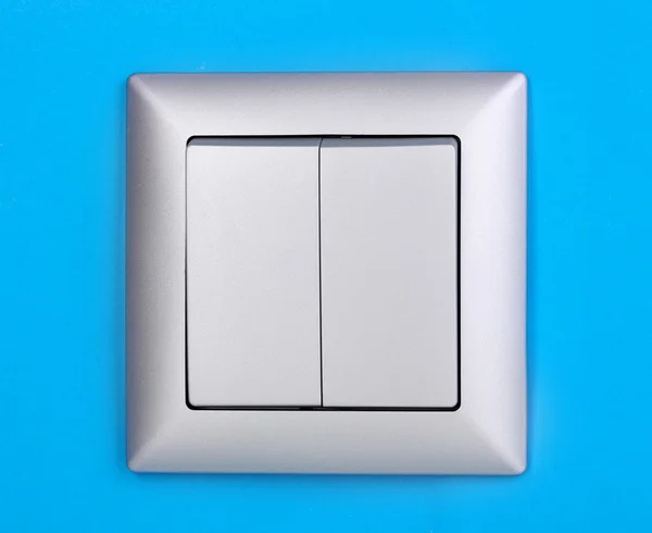 Modern light switch on blue background — Stock Photo, Image