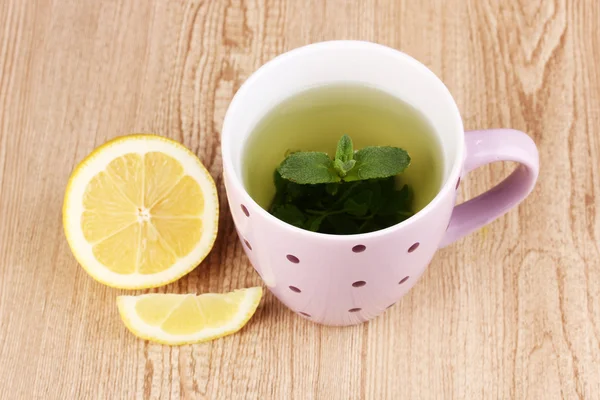 Мятный чай с мятой и лимоном на деревянном фоне — стоковое фото
