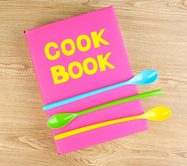 Kochbuch und Geschirr auf Holzgrund — Stockfoto