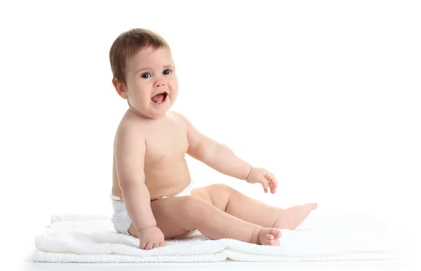 Mignonne bébé fille assis sur serviette isolé sur blanc — Photo