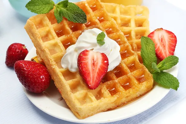 Belgium waffles with honey, strawberries and mint on plate isolated on white — Stock Photo, Image