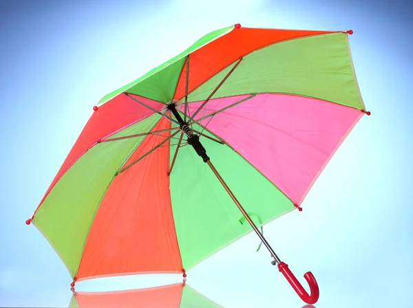 Multi-barevný deštník na modrém pozadí — Stock fotografie