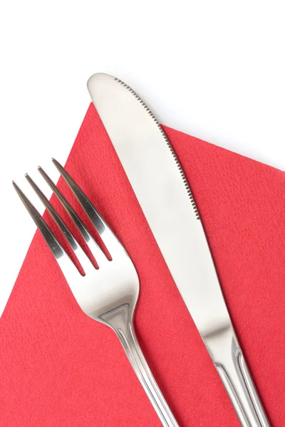 Garfo e faca em um pano vermelho isolado em branco — Fotografia de Stock