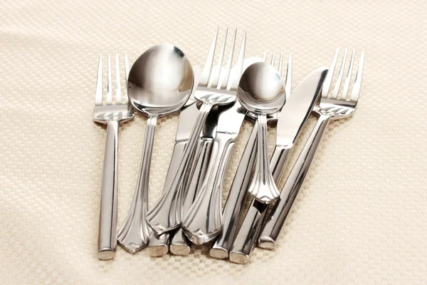 Tenedores, cucharas y cuchillos sobre un mantel beige —  Fotos de Stock
