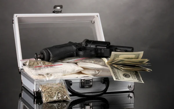Cocaïne en marihuana met pistool in een koffer op grijze achtergrond — Stockfoto