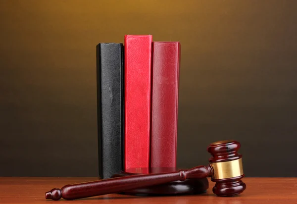 Dommersmal og bøker på trebord med brun bakgrunn – stockfoto