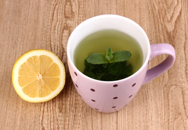Chá de hortelã com folha de hortelã e limão no fundo de madeira — Fotografia de Stock