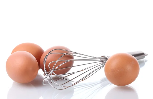 Металлический венчик для взбивания яиц и коричневых яиц, изолированных на белом — стоковое фото