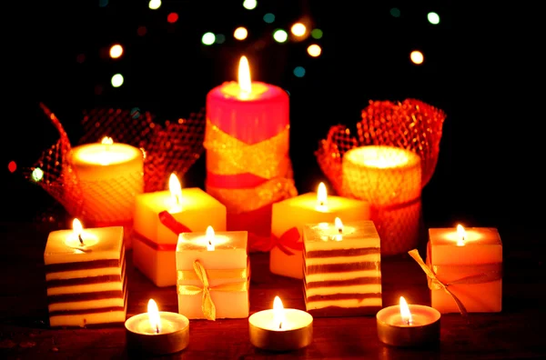 Maravilhosas velas na mesa de madeira no fundo brilhante — Fotografia de Stock