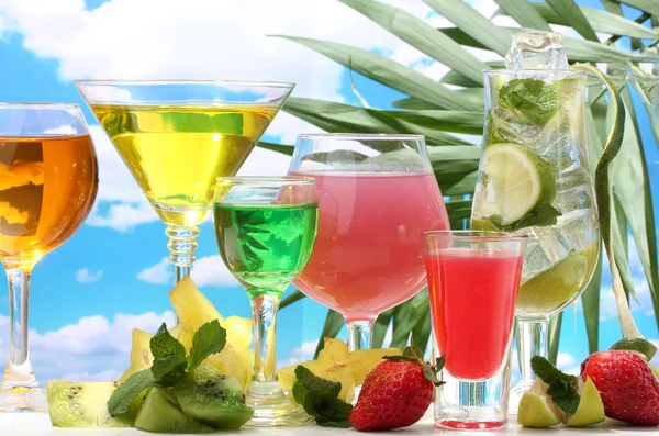 Glasögon av cocktails på bordet på blå himmel bakgrund — Stockfoto