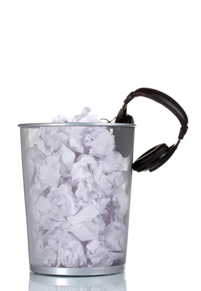 Kopfhörer und Papier im metallenen Mülleimer isoliert auf weiß — Stockfoto