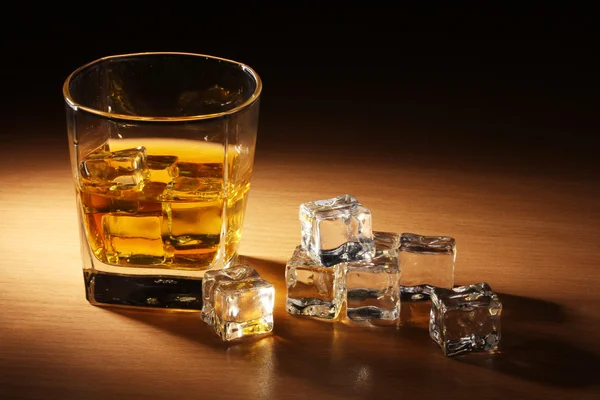 Glas scotch whisky en ijs op houten tafel — Stockfoto