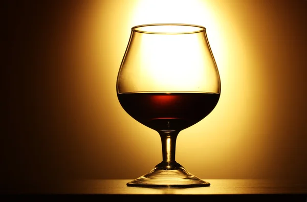 Glas Cognac auf gelbem Hintergrund — Stockfoto