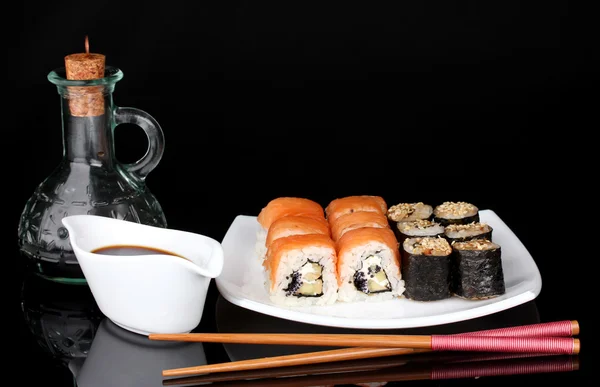 美味卷送达在白板上用筷子和酱油孤立在黑色 — 图库照片