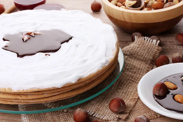 Tårta på glas stå och nötter på träbord — Stockfoto