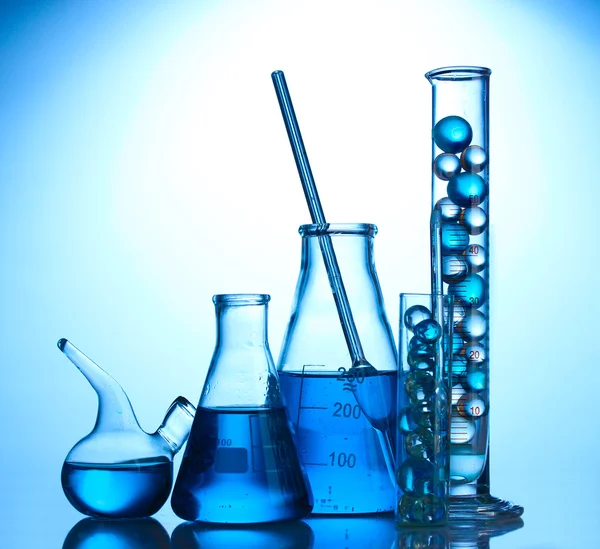 Test-tubes with blue liquid on blue background — Stock Photo, Image