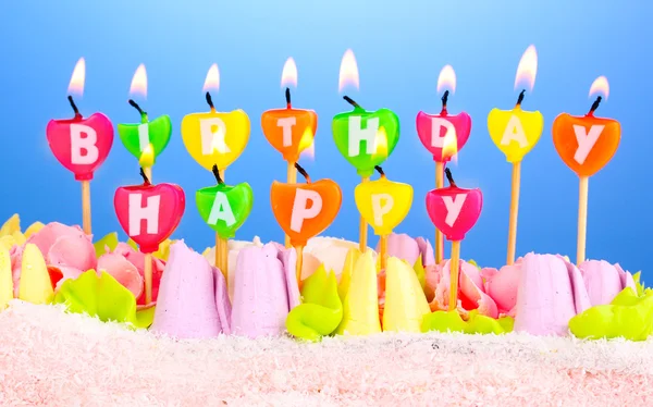 Tort urodzinowy ze świeczkami na niebieskim tle — Zdjęcie stockowe