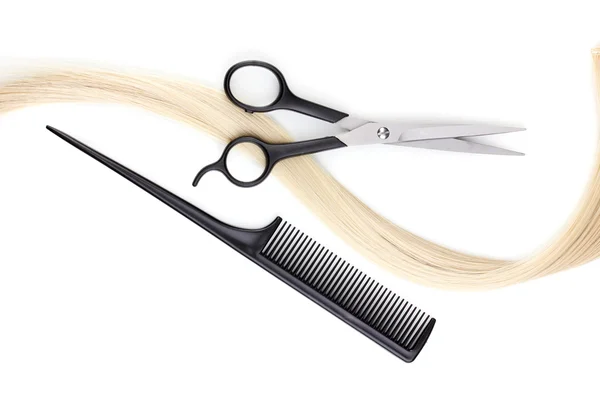 Shiny blond hair with hair cutting shears and comb isolated on white Royalty Free Stock Photos