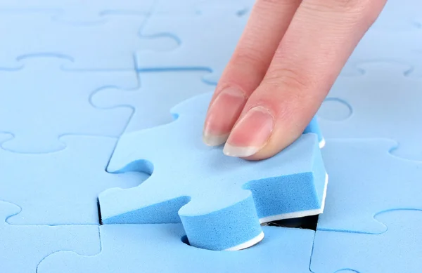 Hand sammelt ein Teil eines Puzzles — Stockfoto