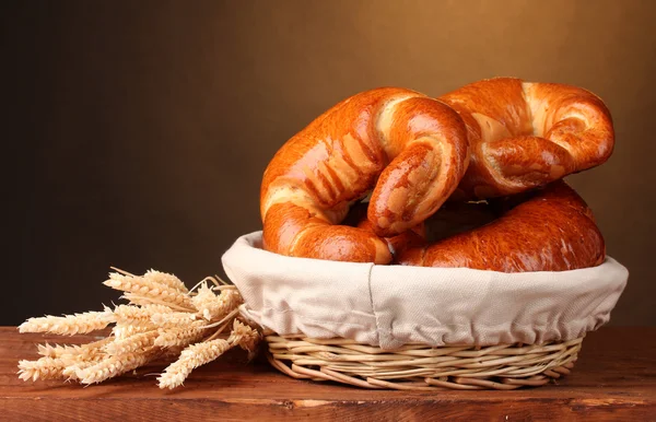 Хлеб в корзине на деревянном столе на коричневом фоне — стоковое фото