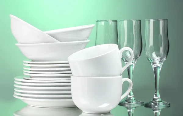 Limpar pratos, copos e copos em fundo verde — Fotografia de Stock