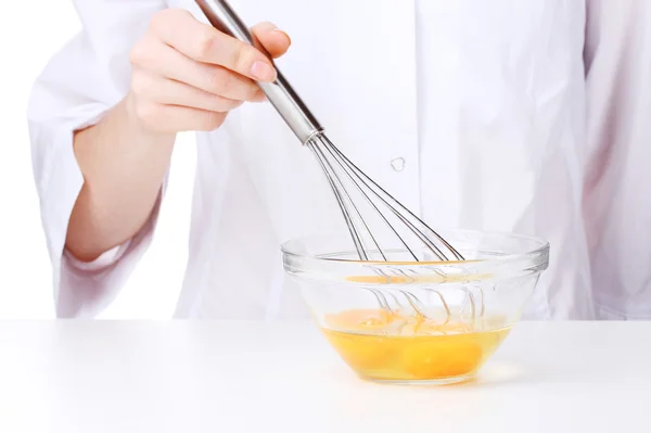 Manos femeninas Mezclando huevos en un tazón aislado sobre blanco —  Fotos de Stock