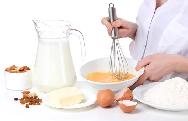 Weibliche Hände vermischen Eier in Schüssel isoliert auf weiß — Stockfoto