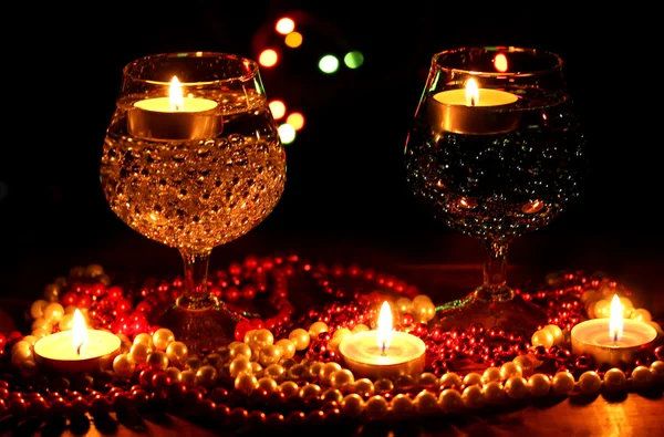 令人惊叹的组成蜡烛和明亮的背景上的木桌上的眼镜 — 图库照片
