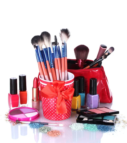 Cepillos de maquillaje en taza y cosméticos aislados en blanco —  Fotos de Stock