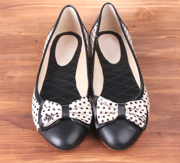 Vrouwelijke platte ballet schoenen patroon met zwarte polka dots op houten achtergrond — Stockfoto