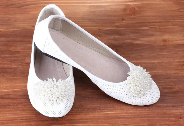 Female white flat ballet shoes on wooden background — Stock Photo, Image