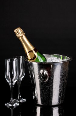 Bottle of champagne in bucket isolated on black clipart