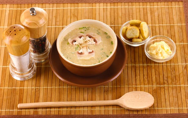 Tasty soup on wooden mat — Stock Photo, Image