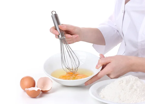 Mãos femininas Misturando ovos em tigela isolada em branco — Fotografia de Stock