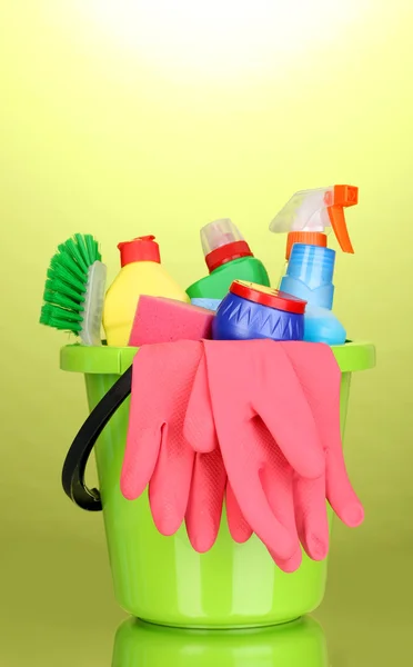 Secchio con articoli per la pulizia su sfondo verde — Foto Stock