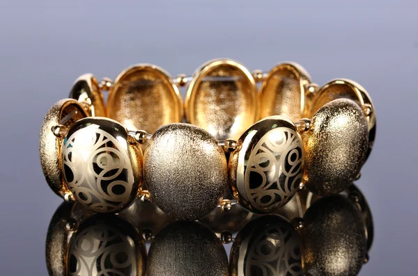 Schönes goldenes Armband auf grauem Hintergrund — Stockfoto