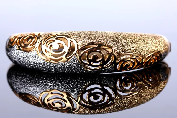 Beautiful golden bracelet on grey background — Stock Photo, Image