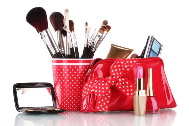 Red glass with brushes and makeup bag with cosmetics isolated on white clipart