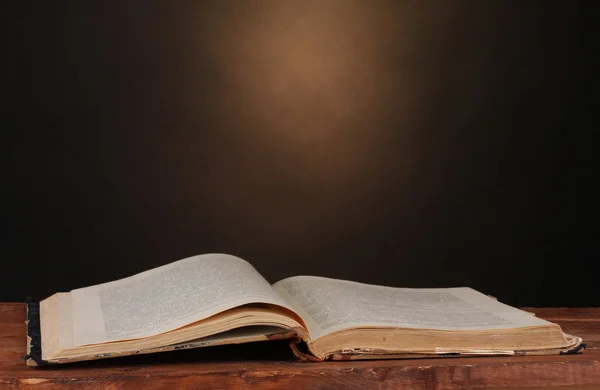 Viejo libro sobre mesa de madera sobre fondo marrón — Foto de Stock