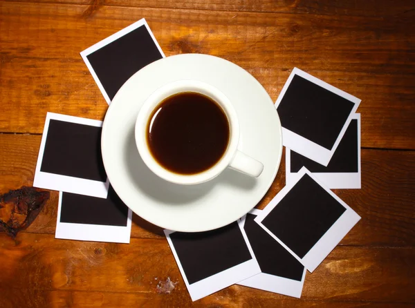 Papéis fotográficos com café sobre fundo de madeira — Fotografia de Stock