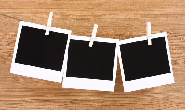 Fotopapiere hängen an der Wäscheleine auf hölzernem Hintergrund — Stockfoto