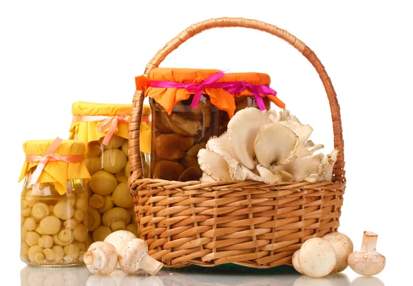 Deliciosos cogumelos marinados nos frascos de vidro, champinhons crus e cogumelos de ostra em cesta isolada em branco — Fotografia de Stock