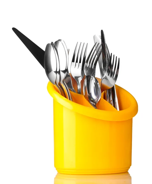 Posate da cucina, coltelli, forchette e cucchiai in stativo giallo su fondo grigio — Foto Stock