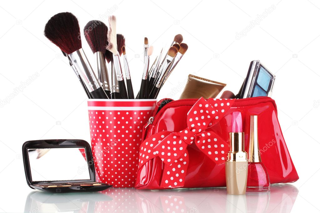 Red glass with brushes and makeup bag with cosmetics isolated on white